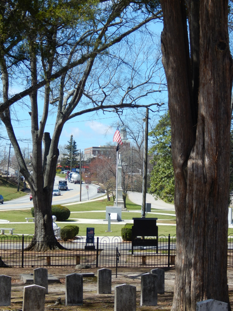 Original photograph of trees, a fence, gravestones and a street beyond